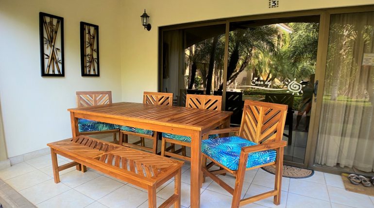 Outdoor Eating Area with glass entry way, screen door, 4 chairs, one bench, 4 seat cusions